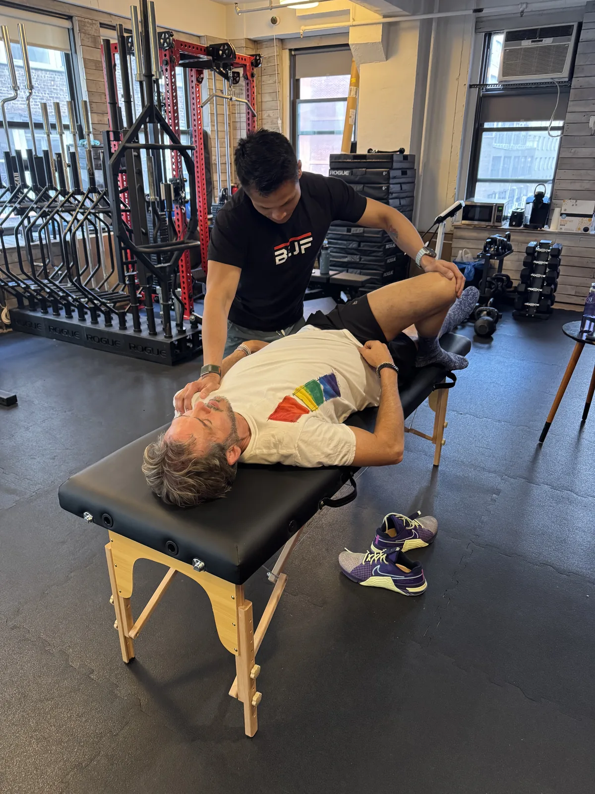 Mobility training for seniors NYC — BUF trainer guiding an older client through hip mobility work at the Midtown Manhattan studio