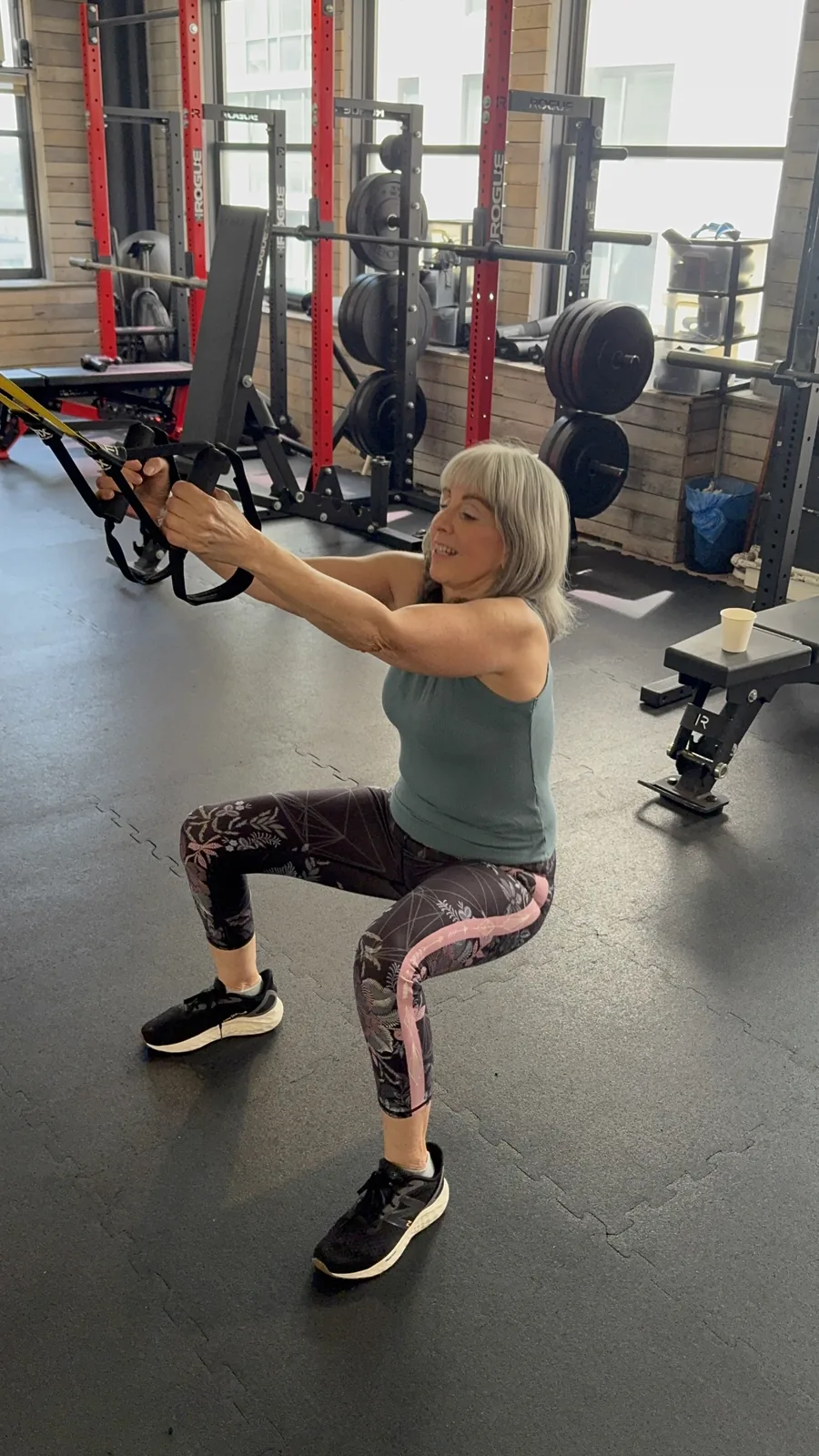 Personal trainer for seniors NYC — BUF Over 50 client doing TRX squats at the Midtown Manhattan studio
