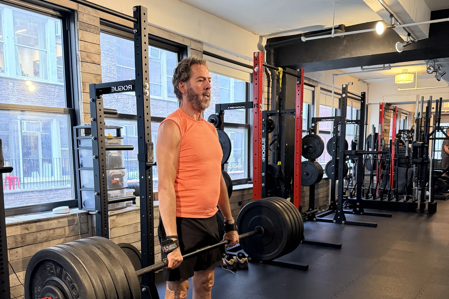 Senior strength training NYC — adult lifting a loaded barbell at the BUF Over 50 Midtown Manhattan personal training studio